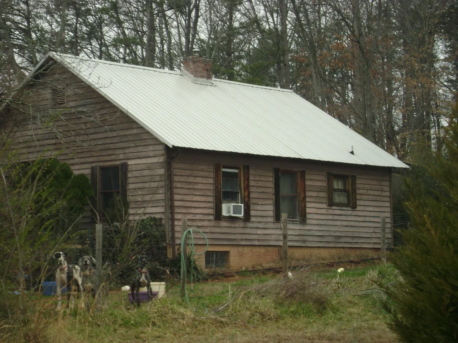 White metal roof on an old wood sided farmhouse, from a Metal Roof Installation job in Clarence
